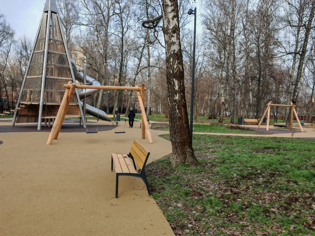 Прогулочная зона с качелями и скамейками для отдыха в парке Подольска