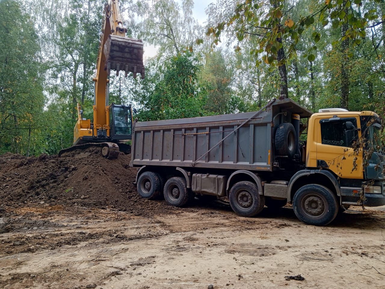 Благоустройство парка Подольск - экскаватор выполняет земляные работы с самосвалом на заднем плане